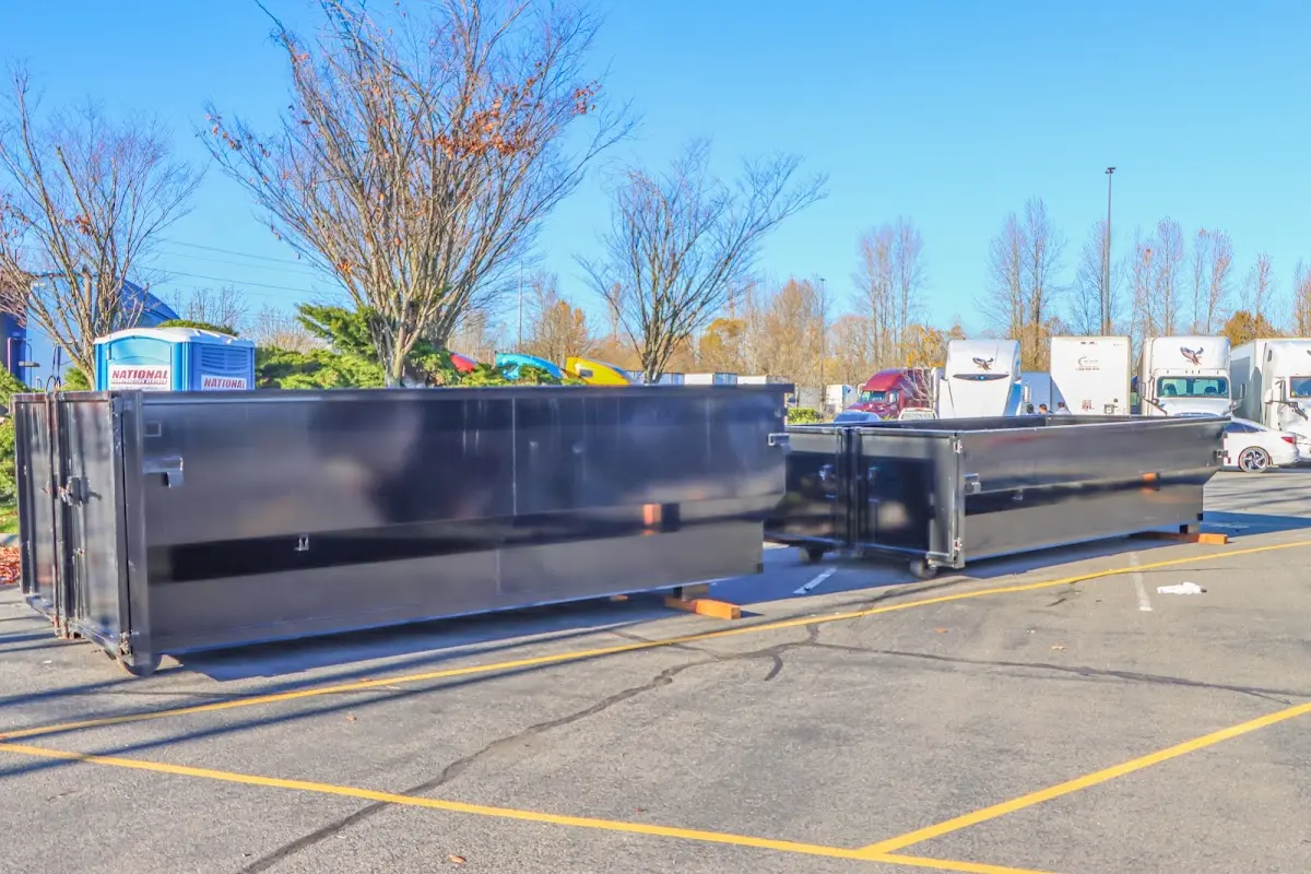 Professional dumpster rental service with roll-off container on residential driveway in Monmouth